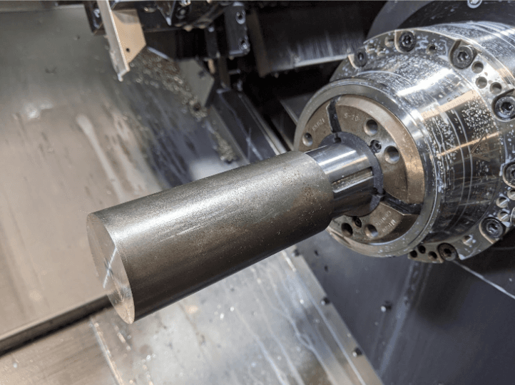 大型碳钢部件(直径 50mm)被夹在 3D 打印的夹头垫块中