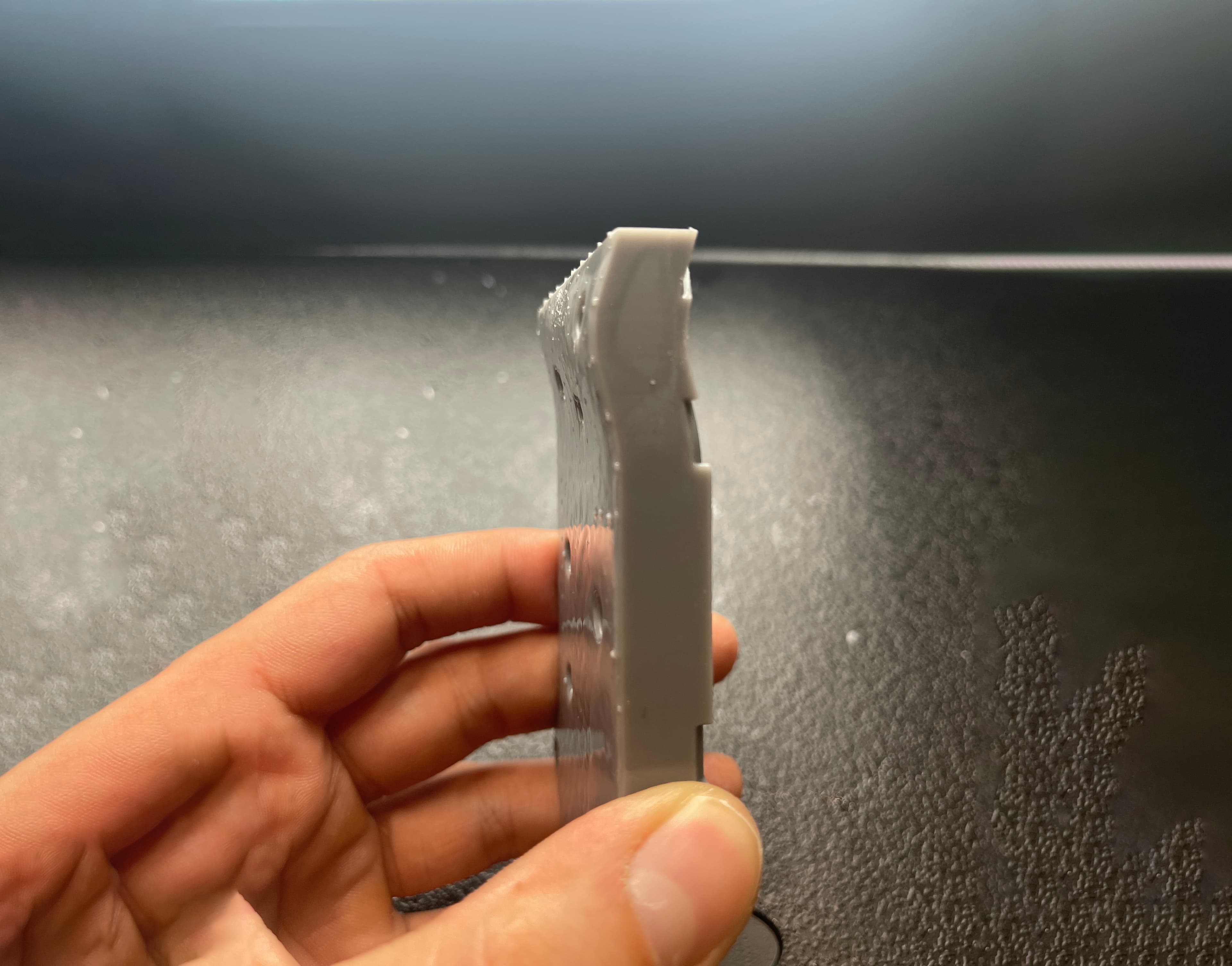 手指握住翘曲的灰色部件