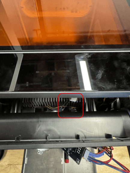 Reach into the machine and free the black motor cable from the machine.