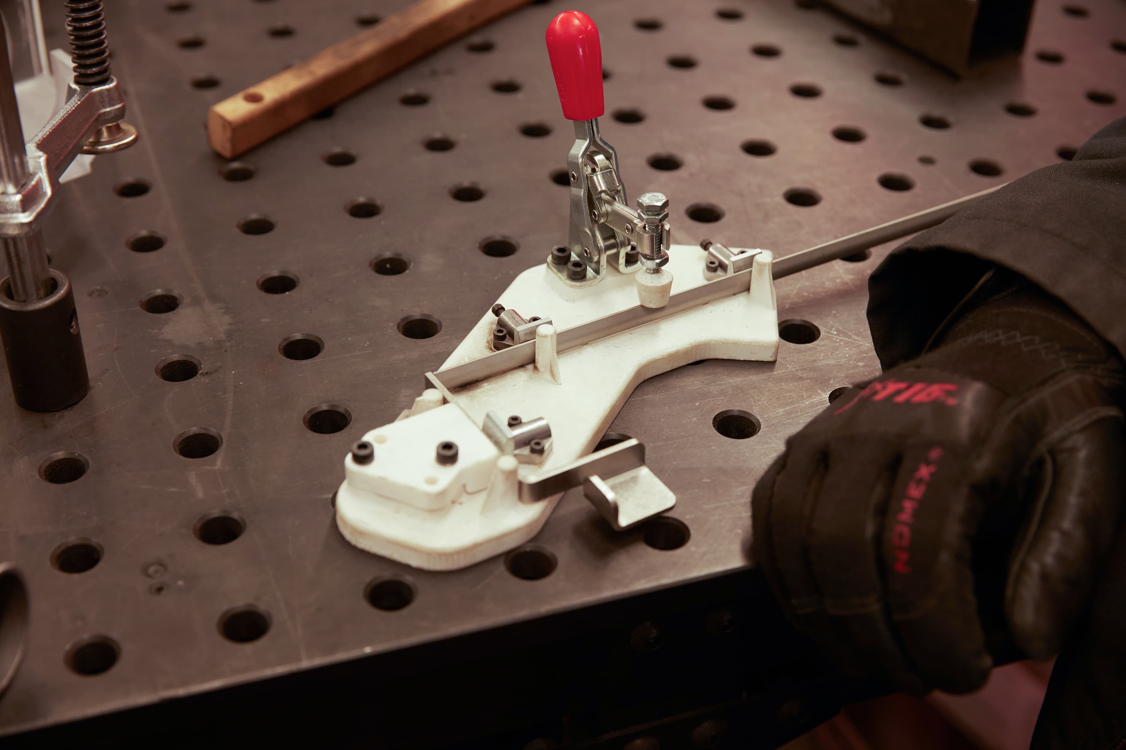 Formlabs 工程师将把手焊接到 Flex Build Platform 原型的杆上时用到的焊接固定装置。该固定装置是利用 Rigid 10K Resin 制造的 3D 打印部件,在焊接了几百个部件之后仍能正常使用。