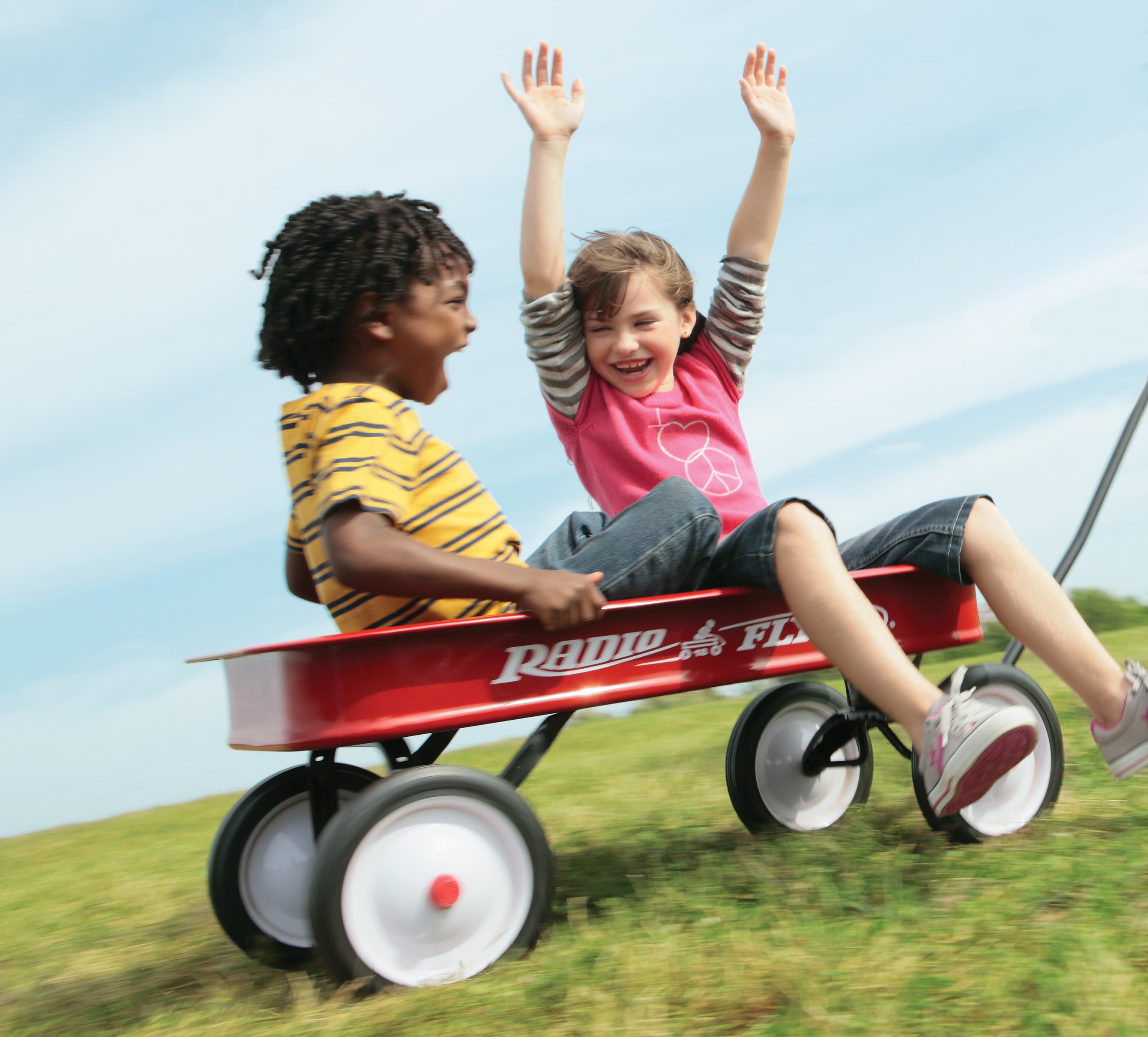 两名儿童坐在 radio flyer 红色儿童手拉车中