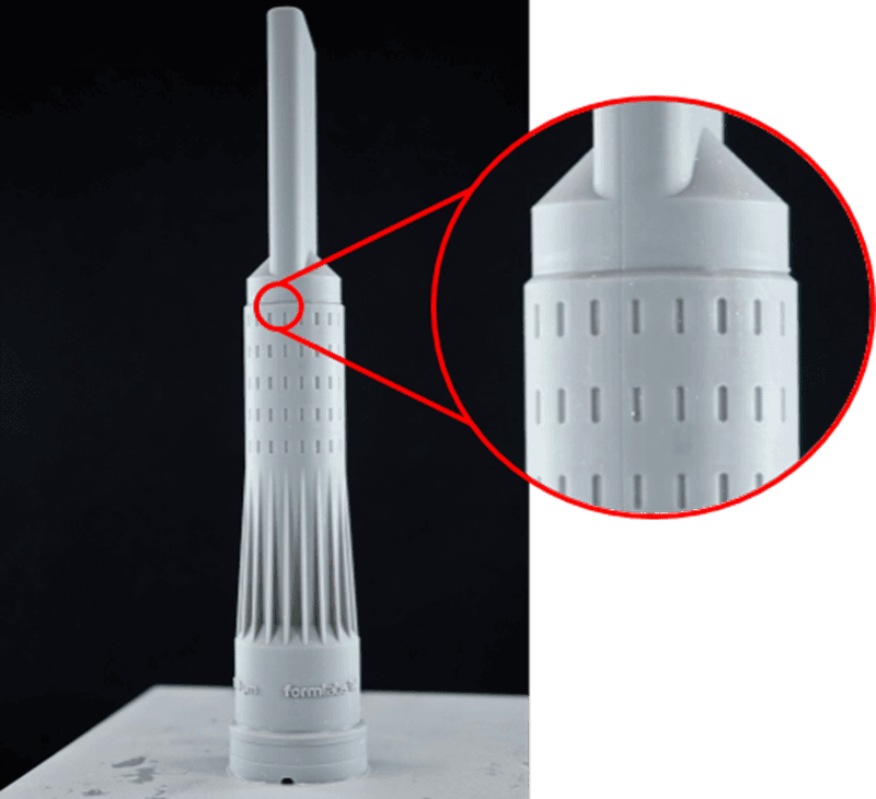清洗后,Formlabs 品牌的吸尘器喷嘴放在构建平台中间。图中显示了接缝线的放大图。