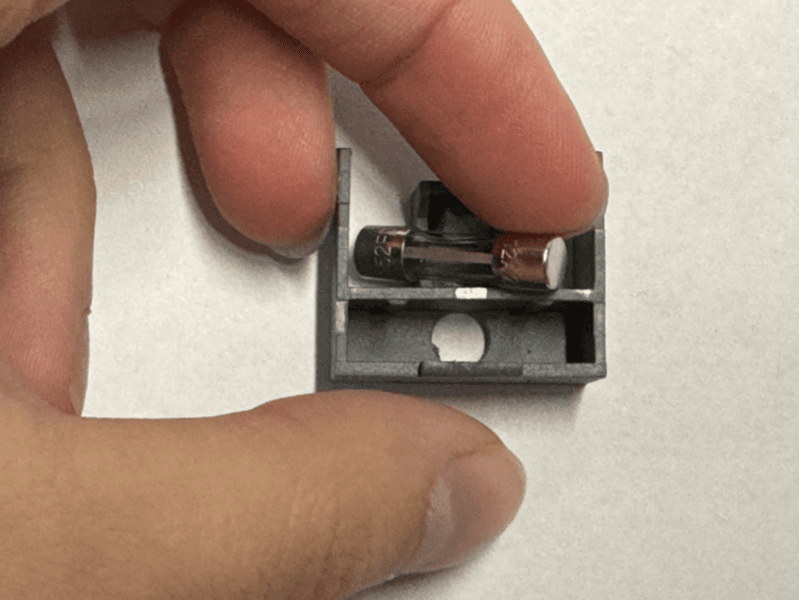 用手指轻轻地将备用保险丝从保险丝盒中撬出。