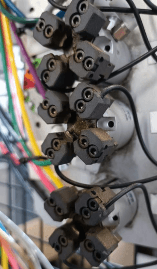 定制化的轻型机械臂端工具 (EOAT),用于拾取经过加热的金属嵌件-带有 32 个钳口的机器人(左)可通过光纤控制部件