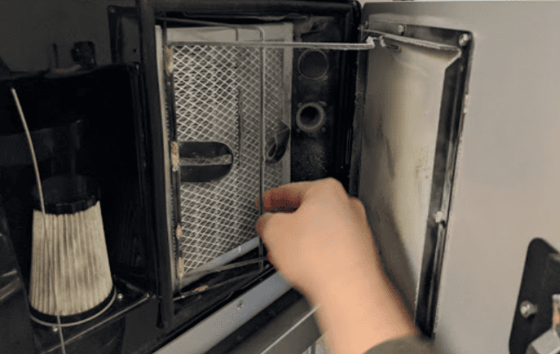 操作人员正在松开排气过滤器底部的保持器挂钩