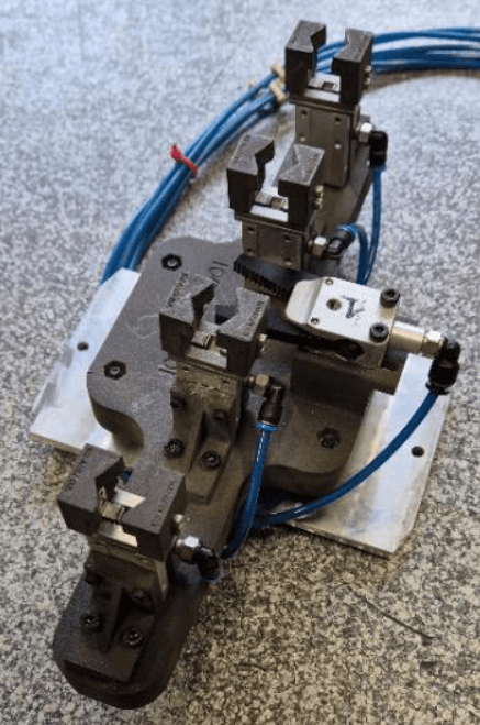 定制化的轻型机械臂端工具 (EOAT),用于拾取经过加热的金属嵌件-带有 4 个钳口的机器人和电路板的机器人(右)都采用了通过 Fuse 系列制造的 3D 打印组件。