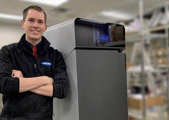 a man stands in front of the Fuse 1+ 30W selective laser sintering (SLS) 3D printer from Formlabs