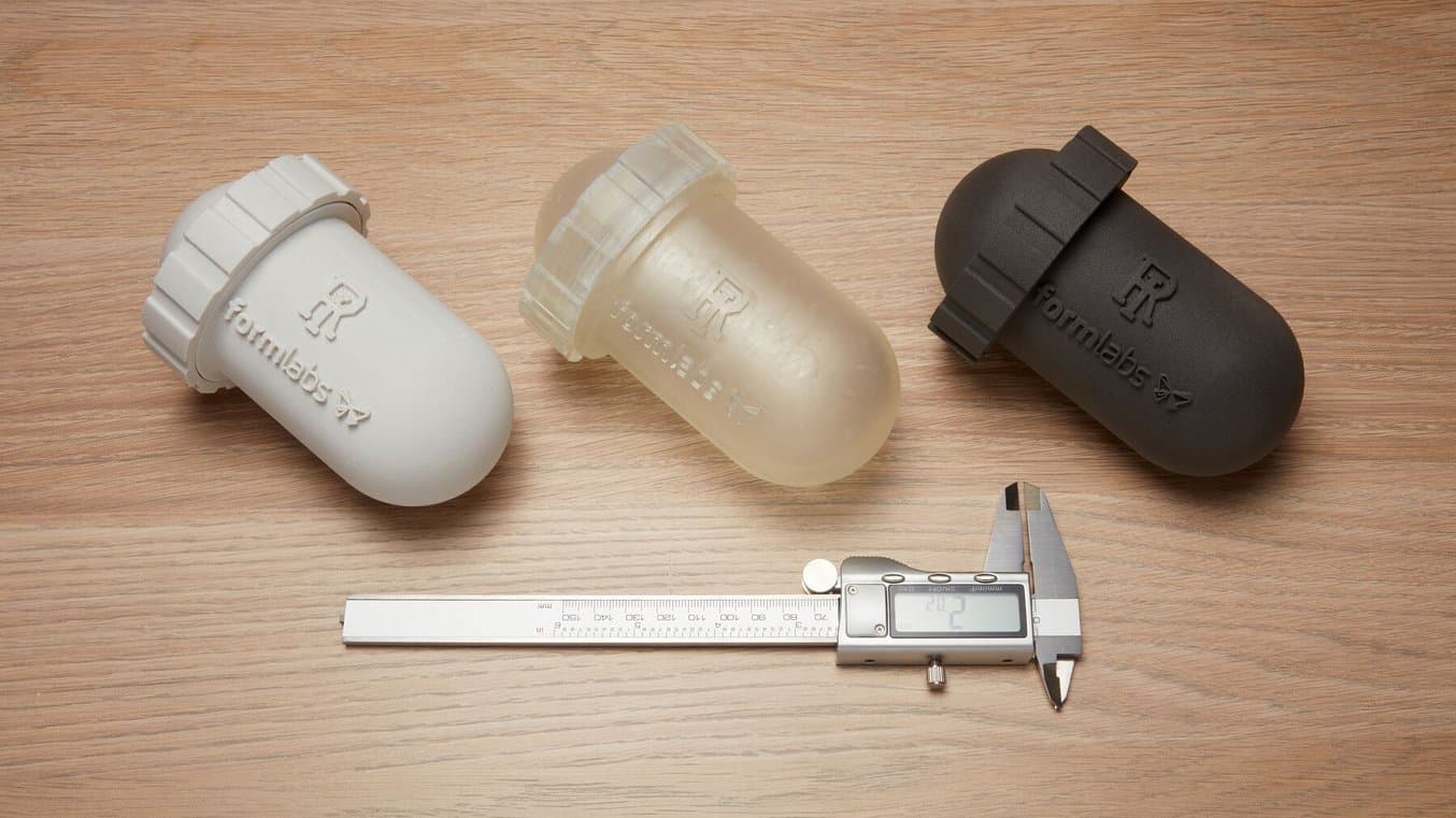 木质背景中的三个防水 3D 打印摄像机外壳