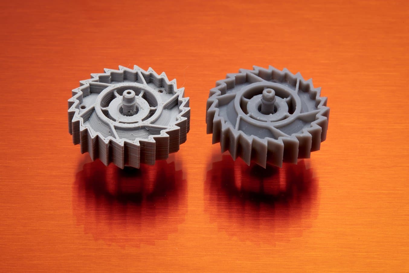 与 FDM 3D 打印机(左)相比,SLA 3D 打印机(右)具有更高的分辨率,能打印出更平滑、更精细的打印件。