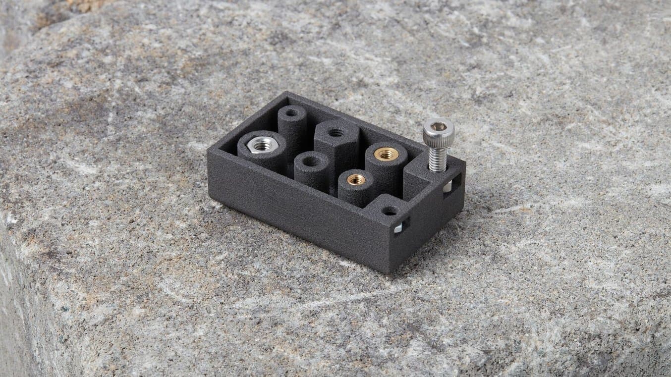 测试部件,其中机器螺丝安装在螺母中,且螺母已插入部件侧面的保护边框中。