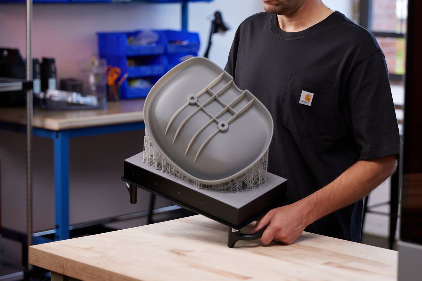 工作人员将一个灰色座椅原型放在 Form 4L Build Platform 上