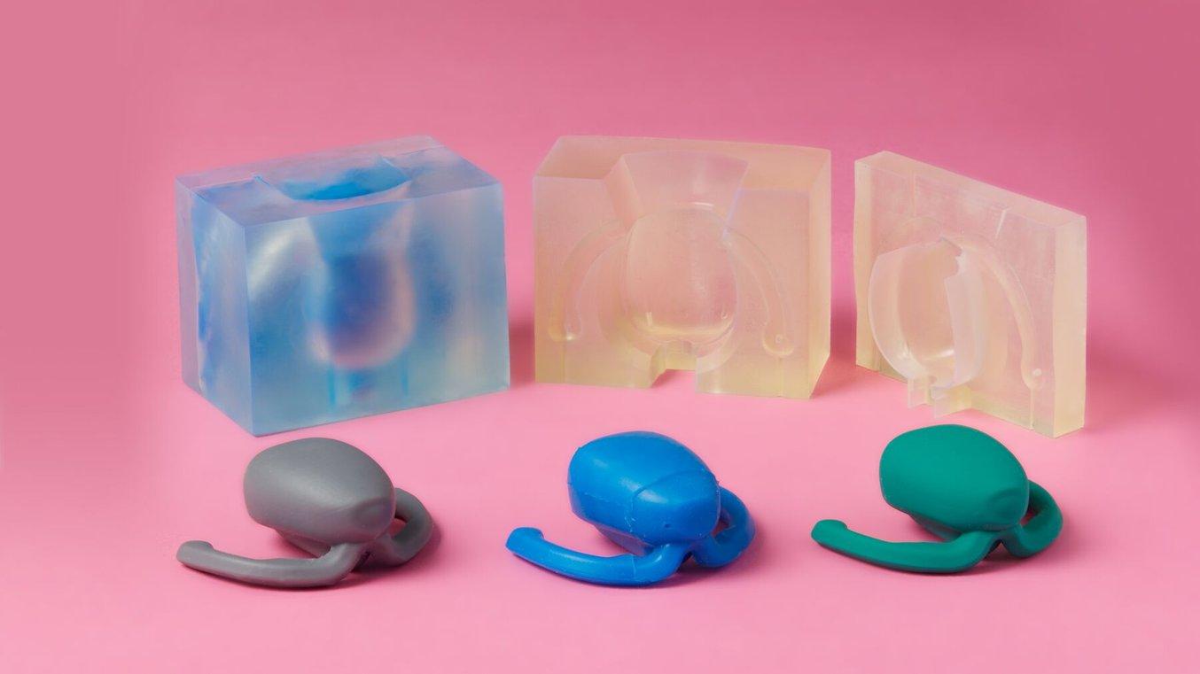 粉色背景中的 3D 打印模具和三个硅胶外壳