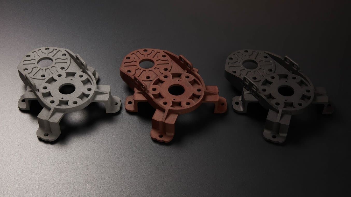 染色前后的试件。其中一个染色部件呈现黑色哑光外观,另一个则呈现深红色哑光外观。